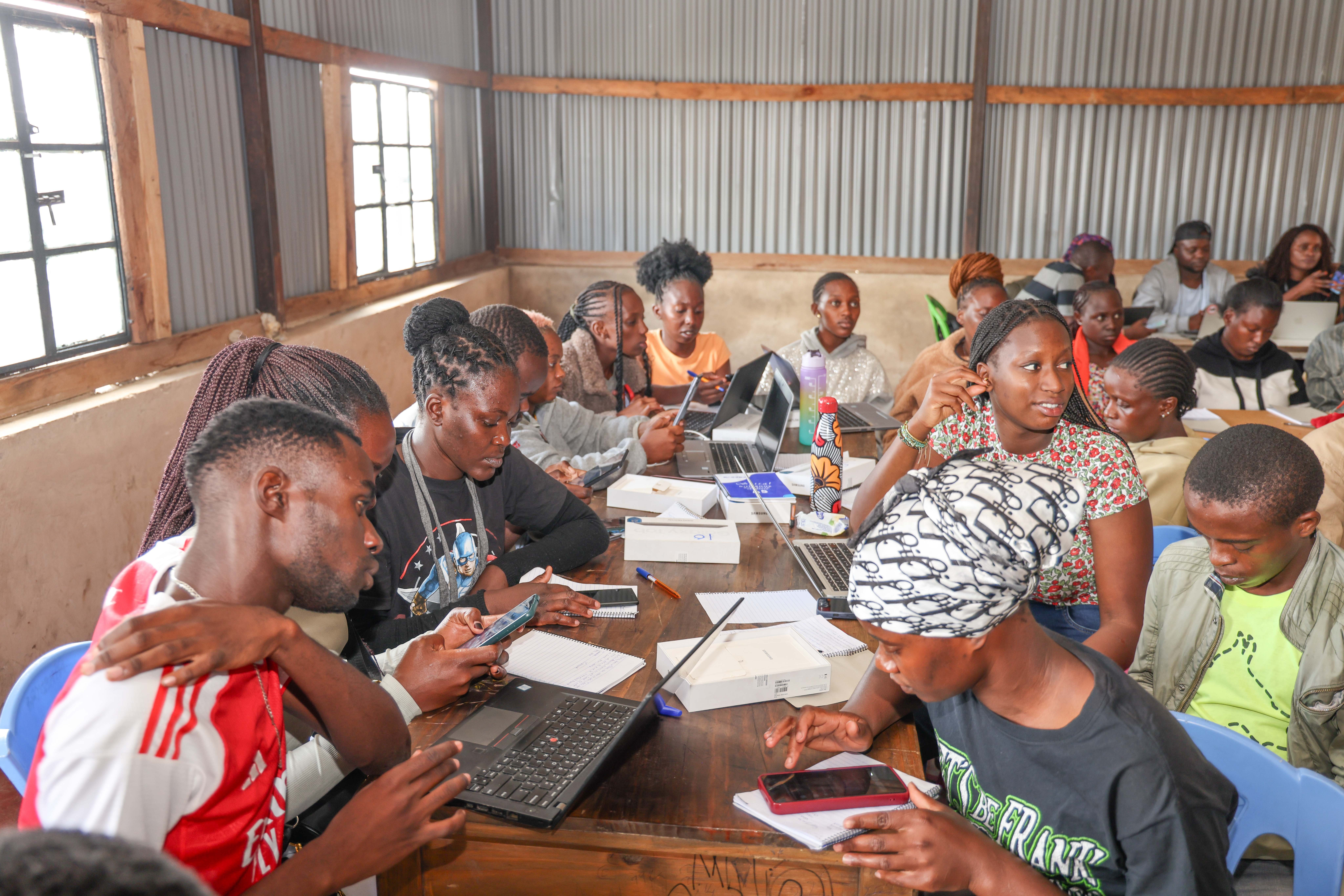 Youth mappers from Muungano wa Wanavijiji collaborate on mapping tasks using tablets and laptops, Ghetto Foundation, Mathare, March 2025. | Photo: HOT / SDI Kenya
