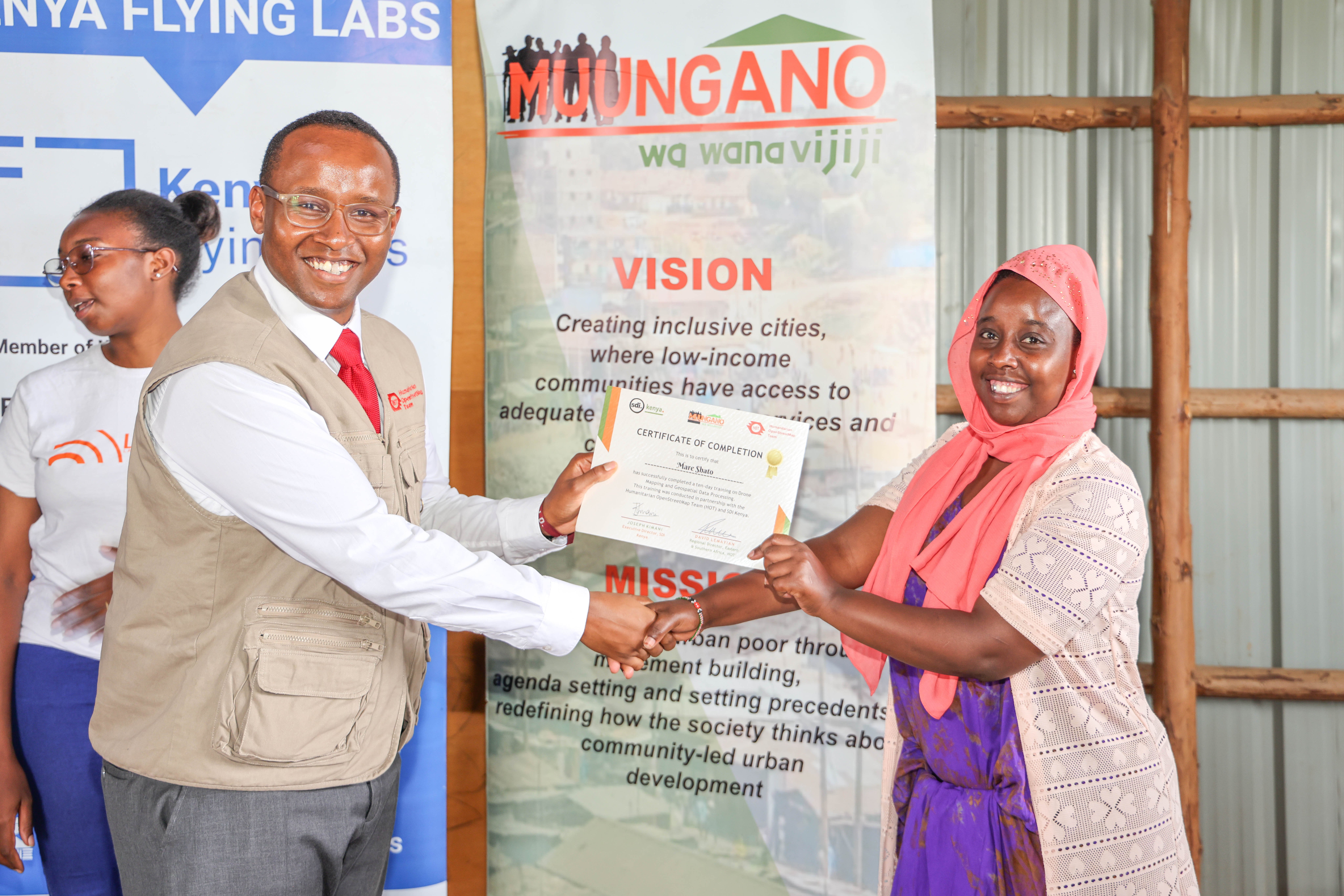 A community youth receives their certificate from HOT Eastern and Southern Africa Hub Director David Lemayian at the KYC Nairobi training certification ceremony, Mathare, March 2025. | Photo: HOT / SDI Kenya