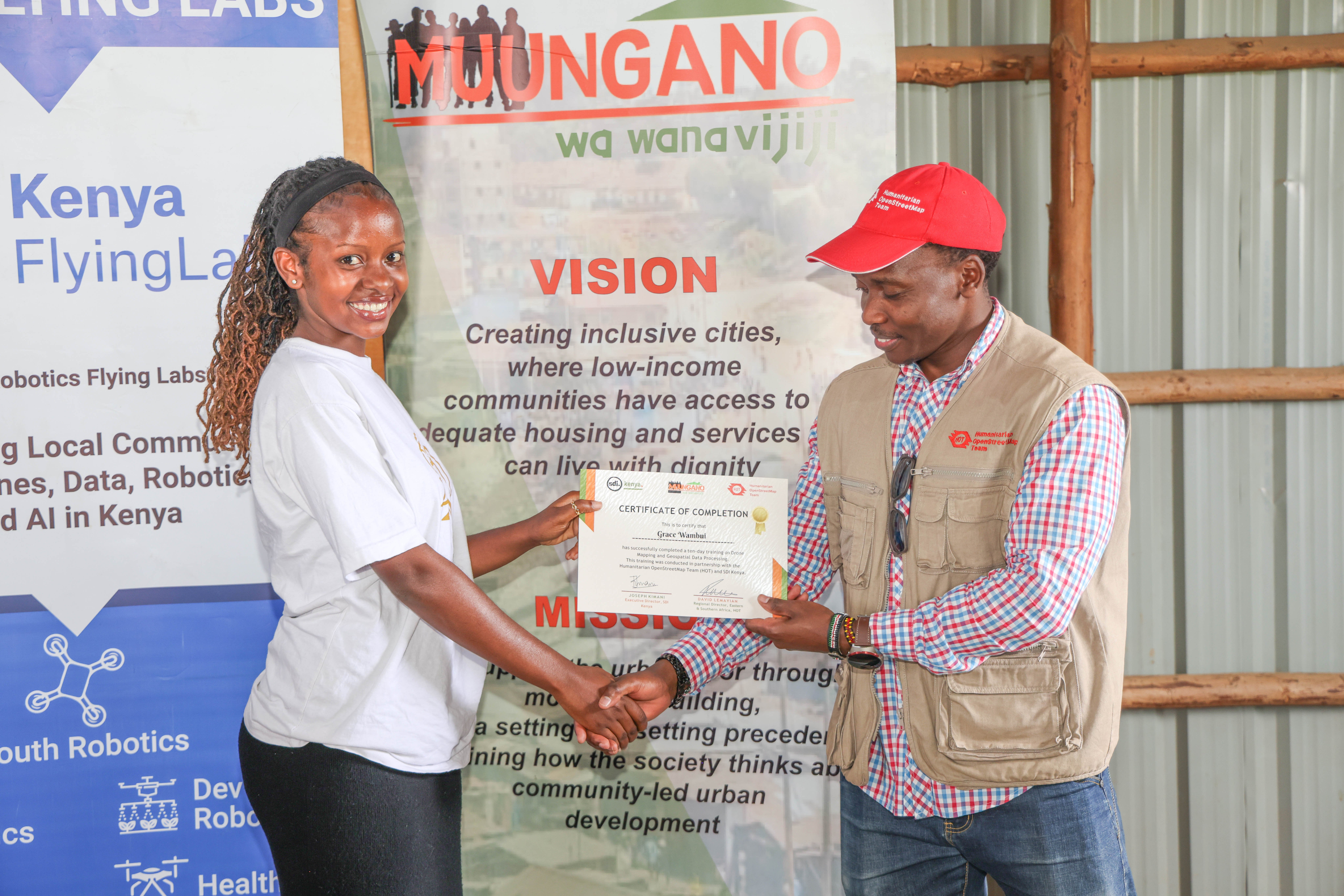 Walter Mayeku, HOT GIS Training Lead, presents a certificate to a participant at the close of the KYC Nairobi geospatial capacity building training, Mathare, March 2025. | Photo: HOT / SDI Kenya